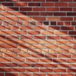 7 Gründe warum Bricks Hanau dein neues Lieblingsziel ist Mann und Frau bauen an einer großen LEGO-Skulptur im Bricks Hanau Store, moderne Innenstadt von Hanau im Hintergrund
