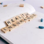 Versicherung in Hanau – Stadtbild mit Brüder-Grimm-Denkmal und einem Versicherungsmakler-Schild